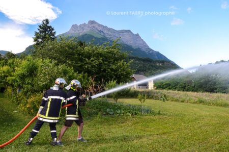 Photographe événementiel pour un centre de secours en Savoie : les sapeurs pompiers volontaires font découvrir aux adultes le maniement de la lance à incendie