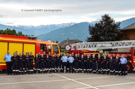 Photographe pour un centre de secours en Savoie : Photo de groupe du centre de secours devant deux véhicules, fourgon et grande échelle