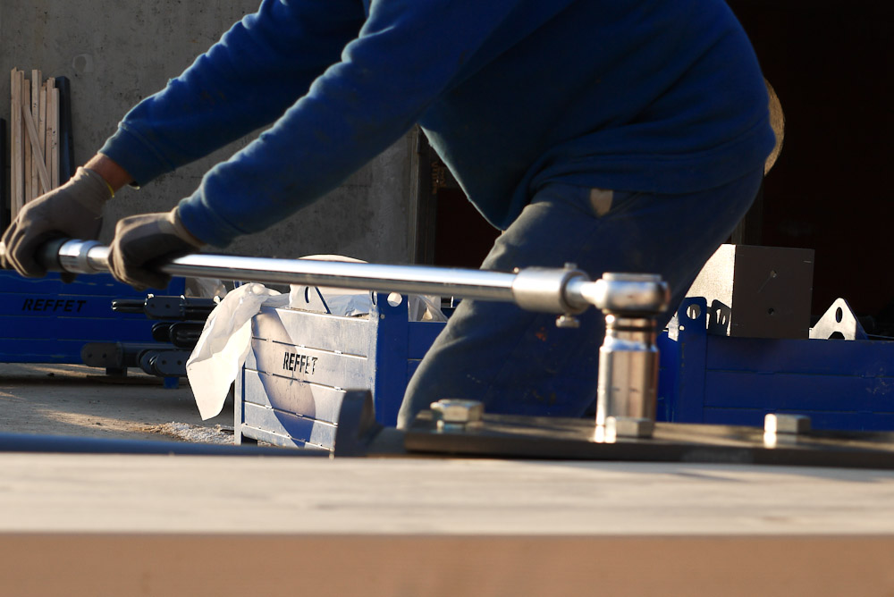Photographe de chantier en Combe de Savoie : à Saint-Pierre d'Albigny : serrage d'un écrou sur des éléments de charpente bois-métal