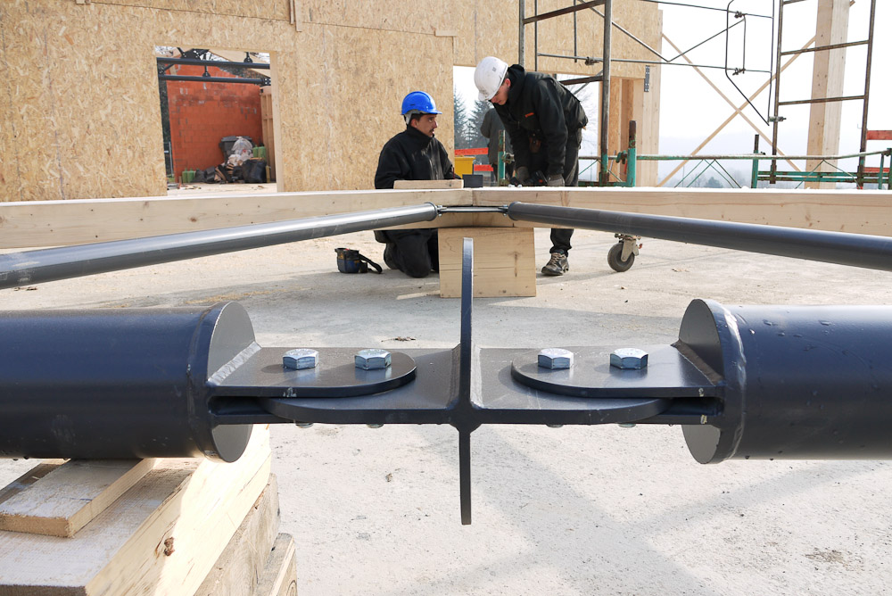 Photographe de chantier en Combe de Savoie : à Saint-Pierre d'Albigny : des charpentiers inspecte un assemblage d'éléments de charpente bois-métal