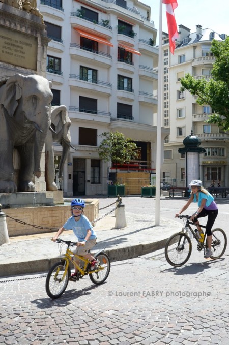 Photographe urbanisme à Chambéry : des enfants passent devant la fontaine des éléphants à Chambéry lors de la sortie vélo