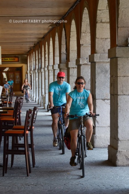 Photographe urbanisme à Chambéry : des cyclistes passent sous les colonnes du Carré Curial à Chambéry
