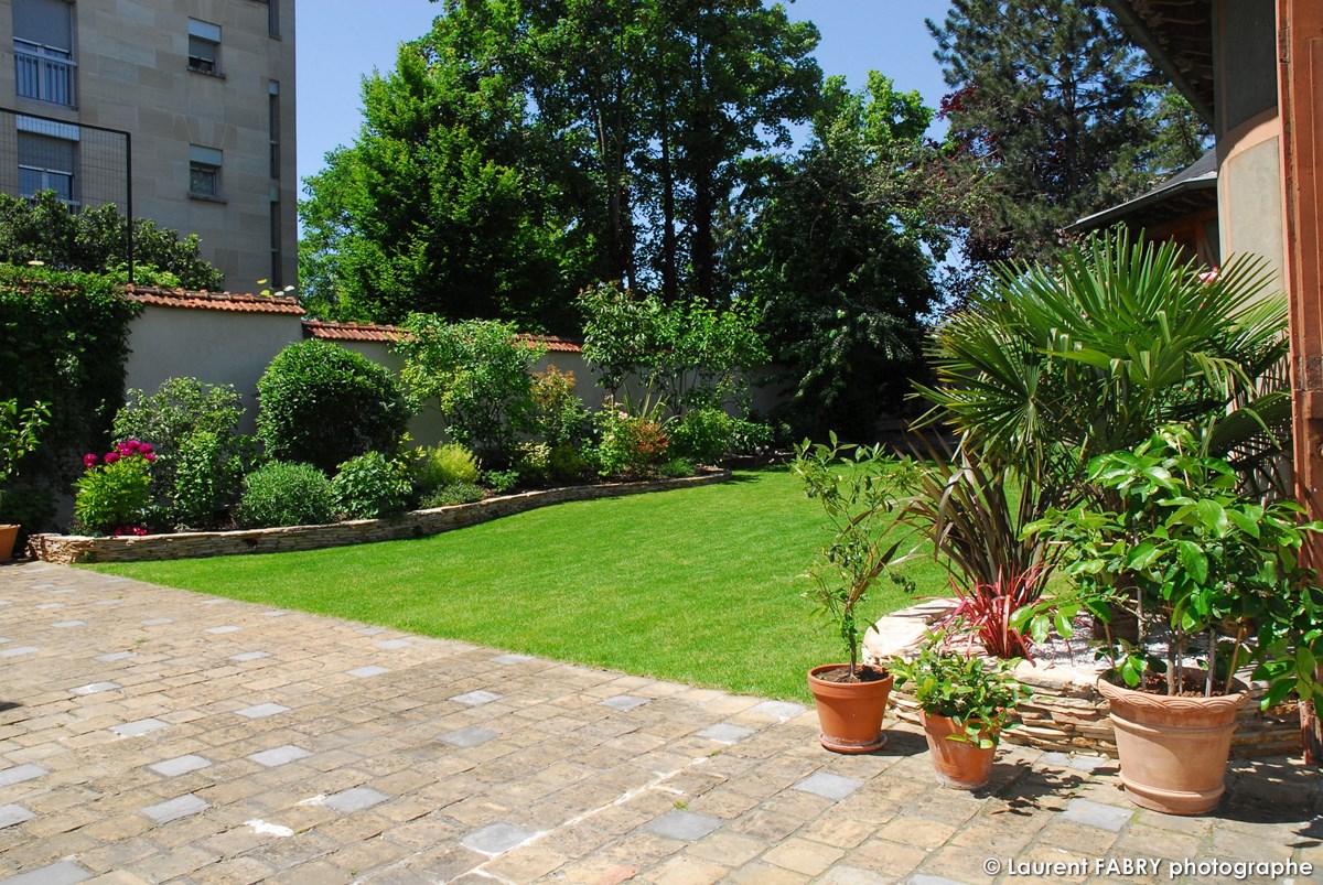 Photographe architecte paysagiste : terrasse, bordures, pots et gazon dans le jardin d'un particulier