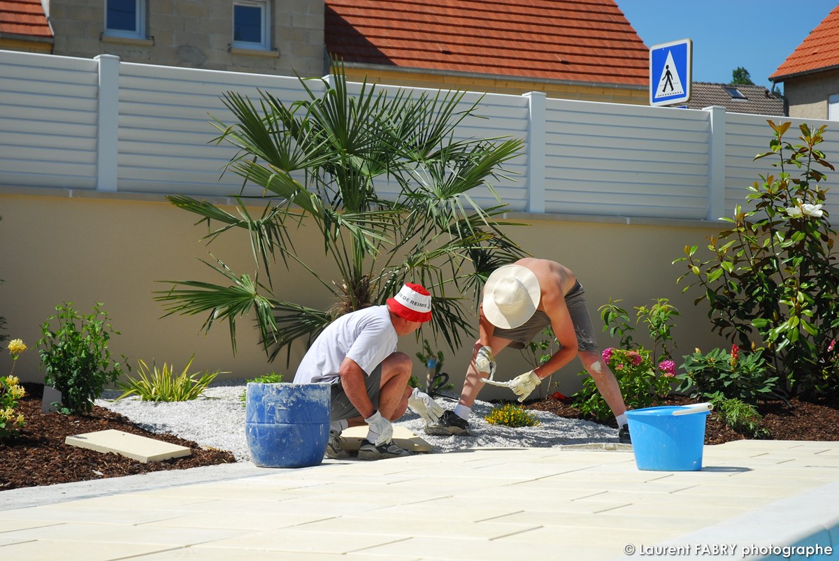 Photographe architecte paysagiste : les ouvriers terminent la terrasse autour de la piscine