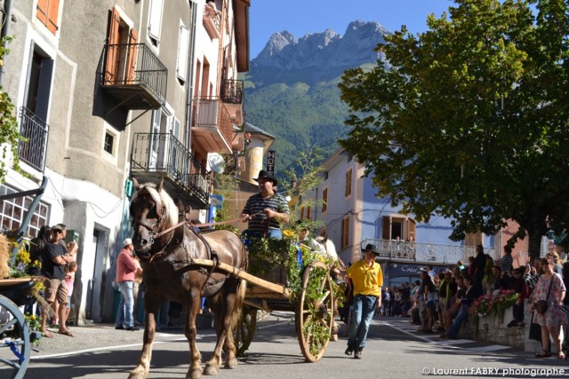 photo d'une calèche traversant la place de l'église devant les spectateurs au centre du village de Saint-Pierre d'Albigny