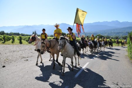 une équipe de cavaliers remonte la route depuis Albigny devant le photographe lors du rallye équestre