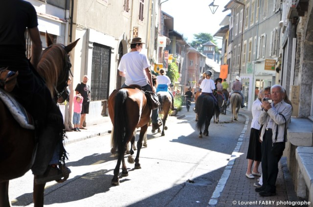 les cavaliers défilent au centre du village devant les passant et le photographe de tourisme équestre à Saint-Pierre d'Albigny