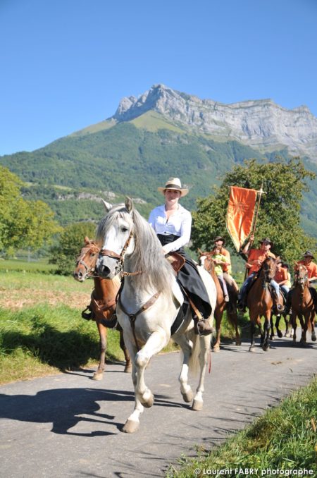 une équipe de cavaliers défile sous la dent d'Arclusaz et devant le photographe de tourisme équestre lors du rallye équestre à Saint-Pierre d'Albigny