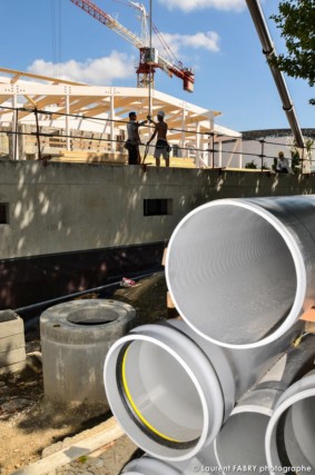 photographe de chantier à Aix-les-bains : deux ouvriers réceptionnent des matériaux apportés par la grue