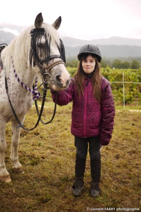 une jeune cavalière pose devant le photographe de tourisme équestre près de son cheval avant le rallye