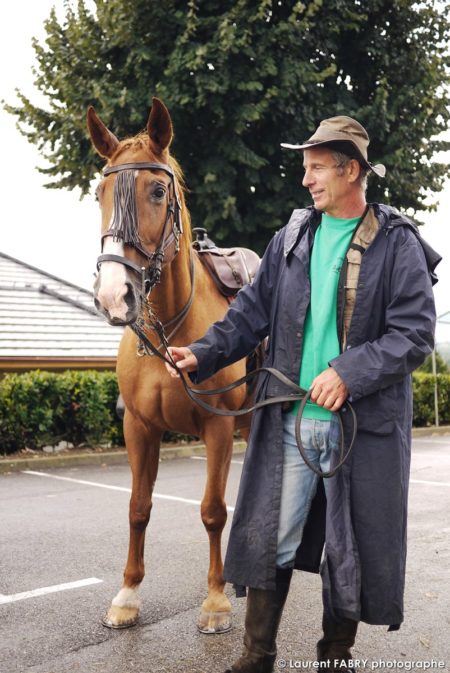 un cavalier pose devant le photographe de tourisme équestre près de son cheval avant le rallye