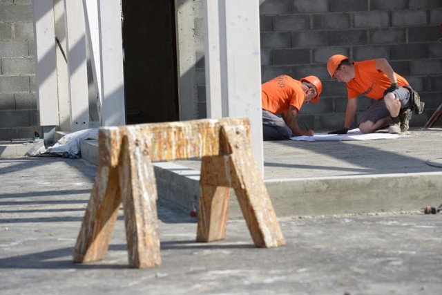 photographe de chantier à Aix-les-bains : des ouvriers consultent un plan posé au sol