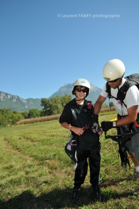 Photographe de parapente en Combe de Savoie : un parapentiste pilote biplaceur déséquipe le jeune garçon qu'il vient de faire voler