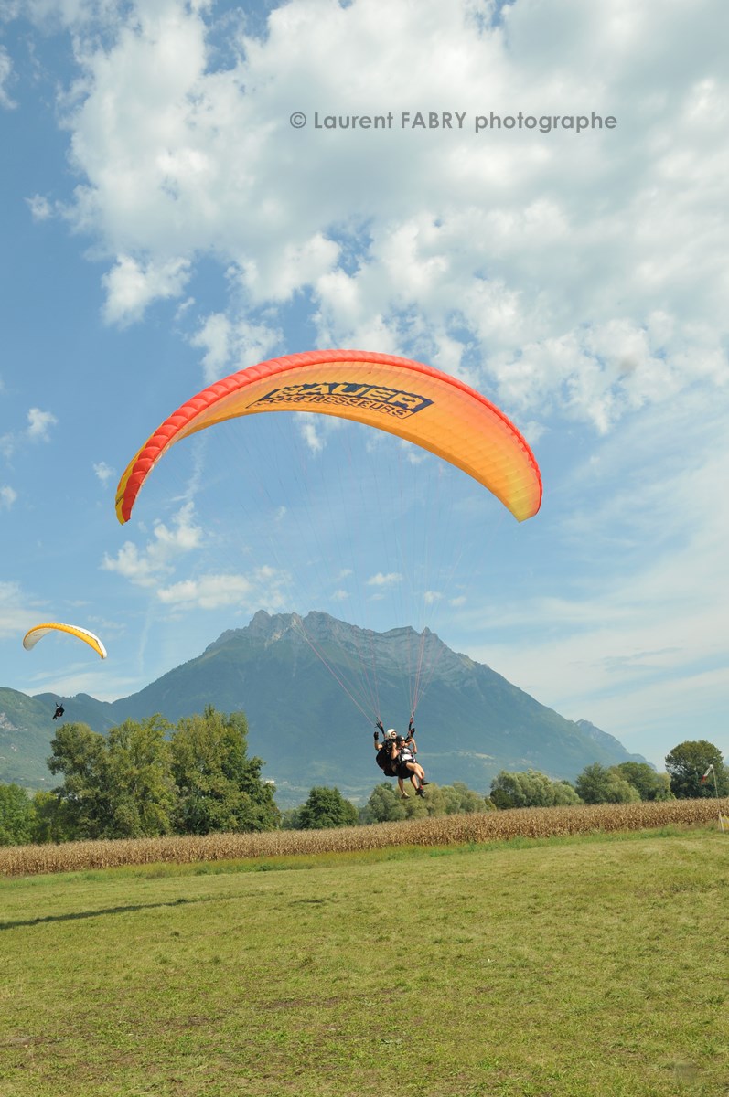 Photographe de parapente en Combe de Savoie : atterrissage d'un parapente biplace devant la dent d'Arclusaz