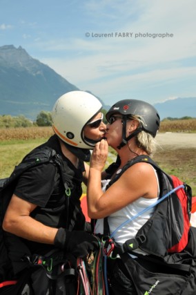 Photographe de parapente en Combe de Savoie : un pilote parapentiste biplaceur embrasse la femme avec qui il vient de voler en Combe de Savoie