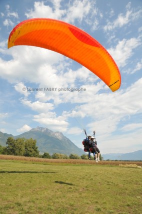 Photographe de parapente en Combe de Savoie : arrivée d'un parapente biplace devant la dent d'Arclusaz