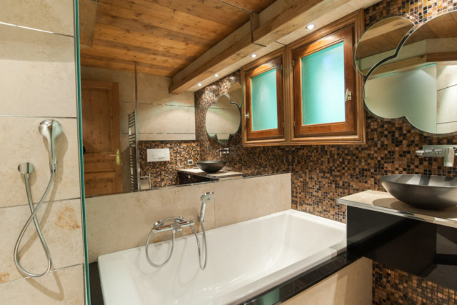 dans un chalet de montagne : salle de bain avec douche et baignoire