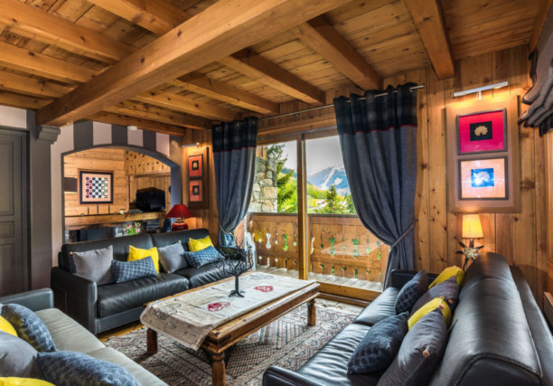 vue d'ensemble des coins salon - salle télé et cheminée dans un chalet de montagne