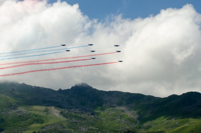 Photographe tourisme sur un meeting aérien : les alphajets de la Patrouille de France dessinent leurs trainées bleu-blanc-rouge dans le ciel de Méribel