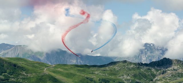 Photographe tourisme sur un meeting aérien : les alphajets de la Patrouille de France dessinent leurs trainées bleu-blanc-rouge dans le ciel de Méribel