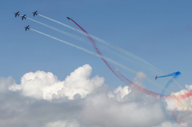 Photographe tourisme sur un meeting aérien : les alphajets de la Patrouille de France dessinent leurs trainées bleu-blanc-rouge dans le ciel de Méribel