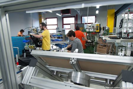 Photographe industrie dans les Alpes en Maurienne : opérateurs sur une ligne de montage