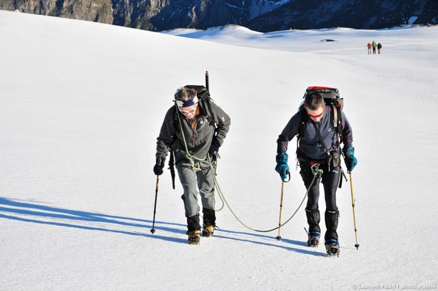 photographe outdoor dans les Alpes : un guide encordé à son client