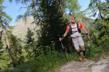 Photographe de trail running en Suisse : un coureur débouche sur un chemin depuis un sentier