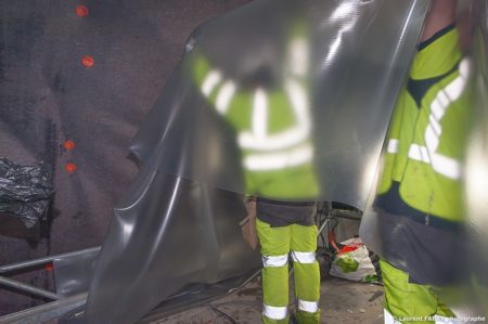 photographe industriel en Auvergne Rhône Alpes : les ouvriers appliquent le matériau plastique d'étanchéité