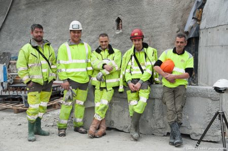 photographe industriel en Auvergne Rhône Alpes : les ouvriers du chantier posent à l'entrée du tunnel devant la Sainte Barbe