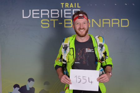 Photographe de trail running en Suisse : coureur montrant son numéro de dossard du TVSB après la course