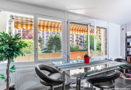 Photographe immobilier pour un appartement à Chambéry : baie vitrée ouverte sur un parc