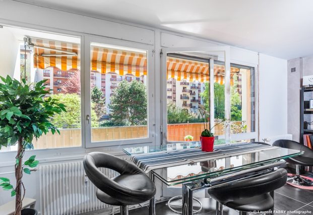 Photographe immobilier pour un appartement à Chambéry : baie vitrée ouverte sur un parc
