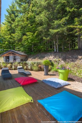 Shooting photo immobilier dans les Alpes : la terrasse du chalet en bordure de forêt