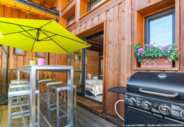 Shooting photo immobilier dans les Alpes : la terrasse du chalet et son barbecue