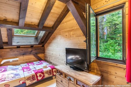 Shooting photo immobilier dans les Alpes : une chambre double donnant sur la forêt