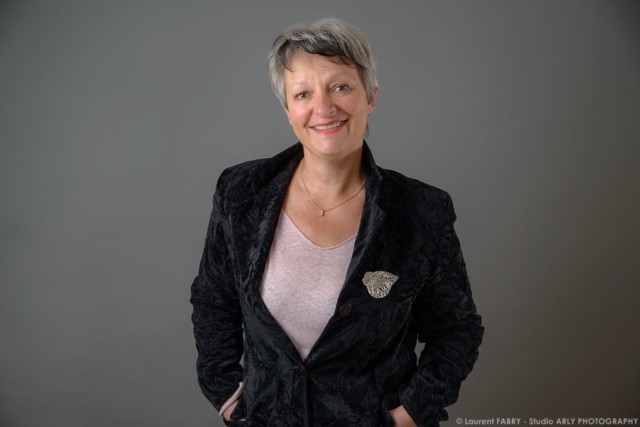 Photographe portrait souriant en studio sur fond gris