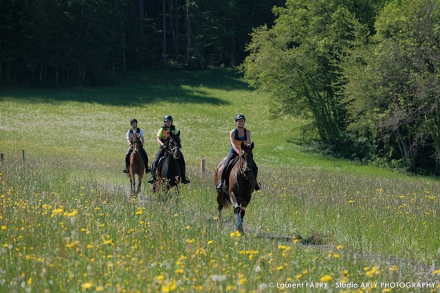 Des cavalières dans un champs de fleurs lors du raid multi-sports en Haute Savoie