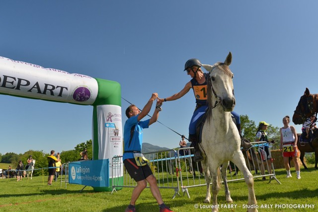 Passage de témoin entre un coureur à pieds et une cavalière lors du raid multi-sports en Haute Savoie