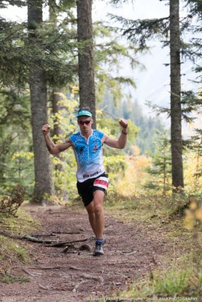 Un trailer lève les bras pendant la course dans la forêt