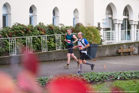 Deux coureurs de trail passent devant les thermes pendant leur course