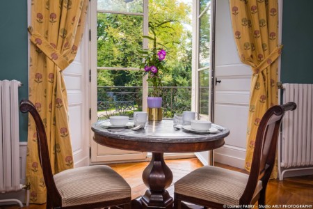 Photographe hôtel pour le Château de Maillat : table dans une chambre donnant sur les jardins