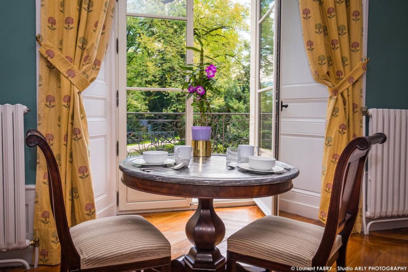 Photographe hôtel pour le Château de Maillat : table dans une chambre donnant sur les jardins