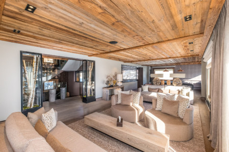 Photographe chalet à Megève : grand salon ouvert sur l'escalier dans un chalet de prestige à Megève