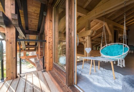 Photographe chalets de luxe en Haute Savoie : un pallier avec vue et balaçoire dans les chalets Bovard