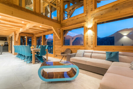 Photographe chalets de luxe en Haute Savoie : une salle à manger par une belle lumière du soir dans les chalets Bovard