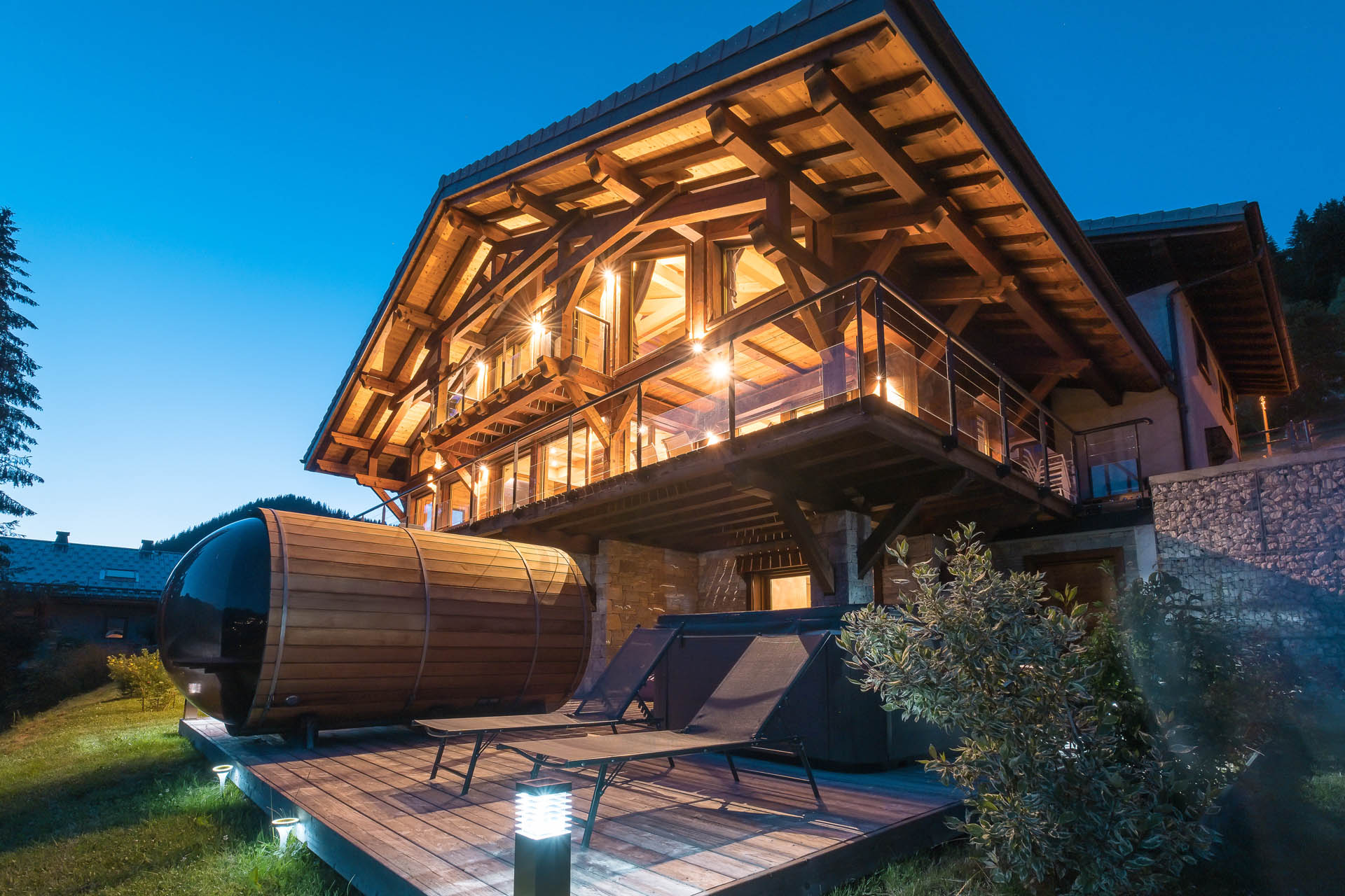 Photographe chalets de luxe en Haute Savoie : une façade par une belle lumière du soir des chalets Bovard