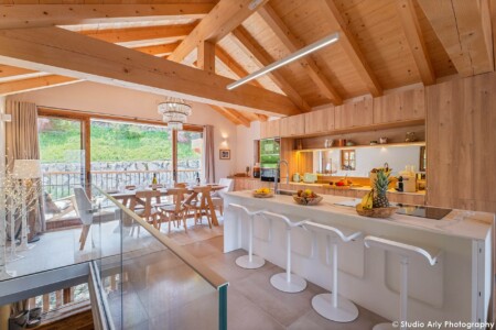 Photographe chalet de luxe dans les Alpes : la salle à manger et sa grande baie vitrée