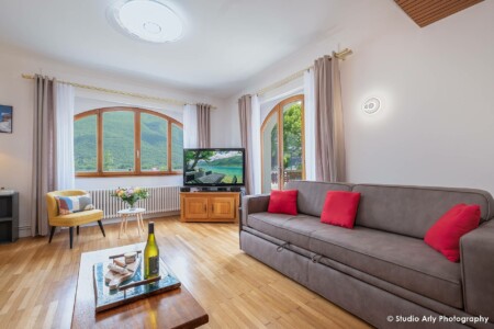 Photographe immobilier au lac d'Annecy : le grand salon et ses deux canapés convertibles