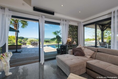 Photographe immobilier dans l’avant-pays savoyard : coin salon ouvert sur terrasse